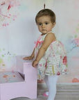 Baby girl wearing white tights with pink shoe design