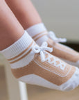 Light brown infant or toddler socks with fake shoelaces look like shoes