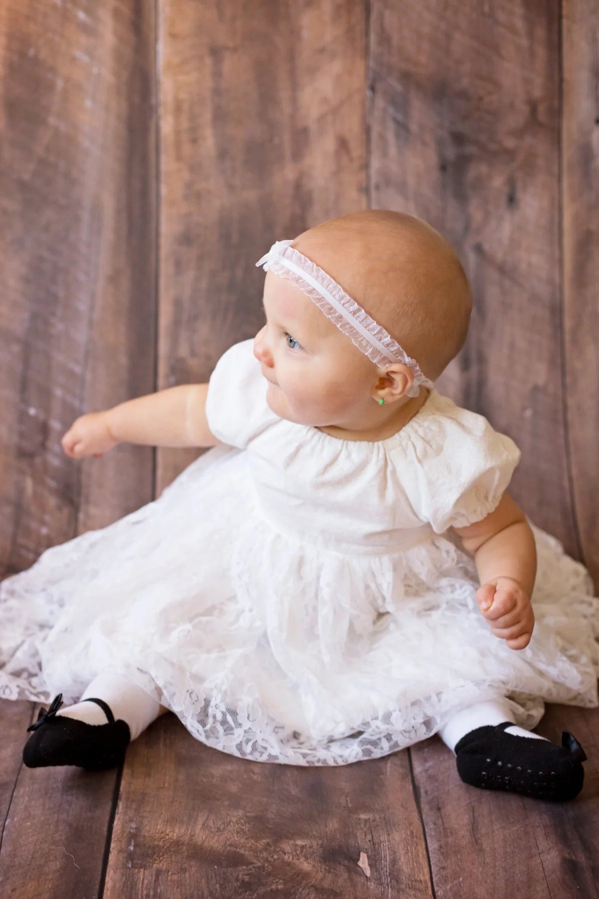 Toddler girl with white dress wearing black Mary Jane shoe socks by Baby Emporio