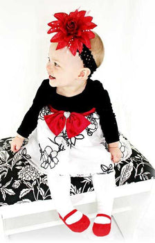 Little girl 6-12 months wearing fancy dress and Baby Emporio footed legging tights with red shoe-look