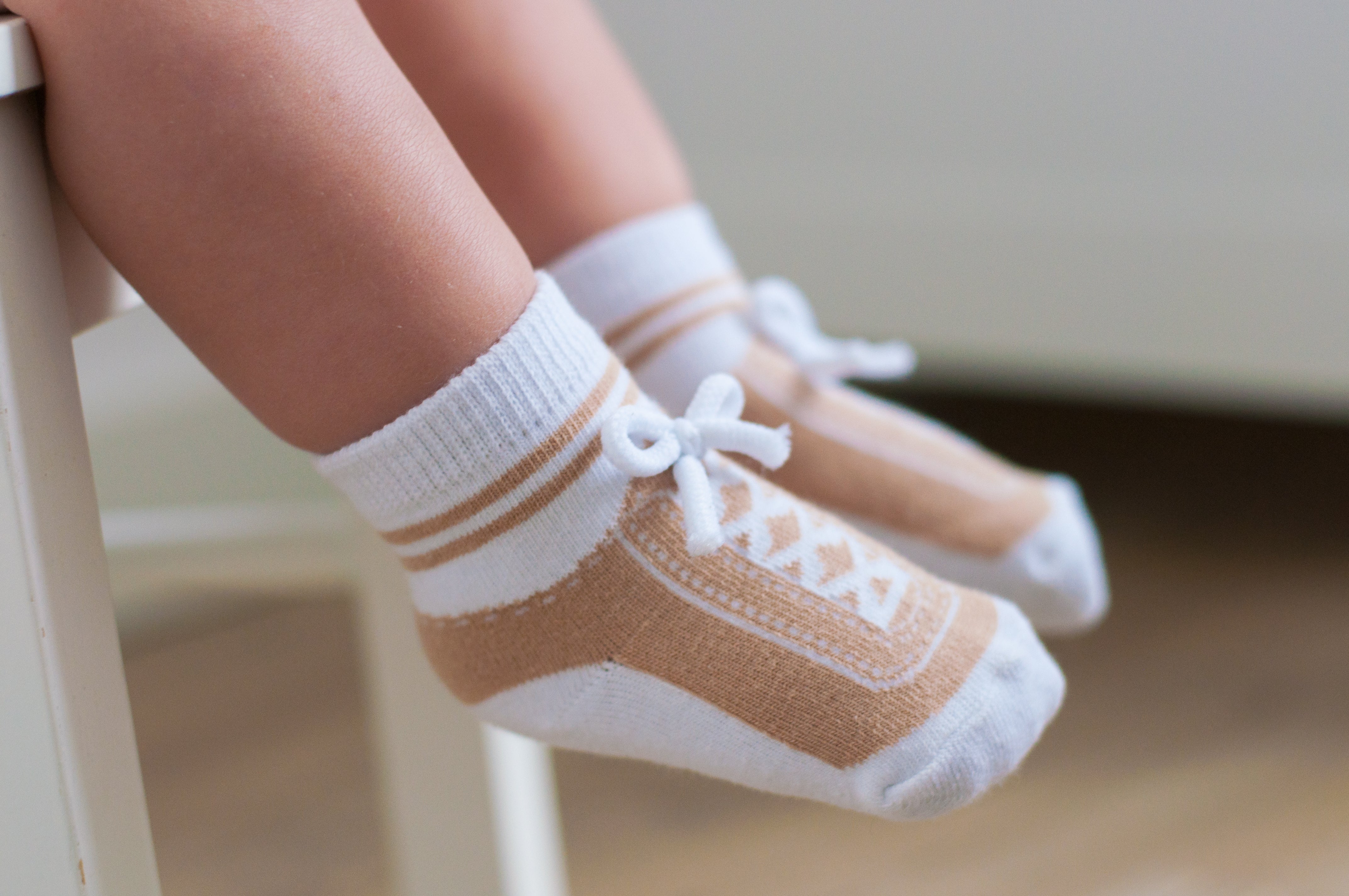 Light brown infant or toddler socks with fake shoelaces look like shoes